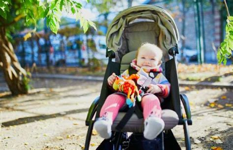 bambino nel passeggino protetto dal sole con un ombrellino