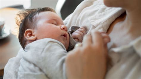 Bambino che dorme in braccio al genitore