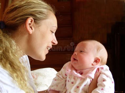 madre e neonato che si guardano negli occhi in un passeggino