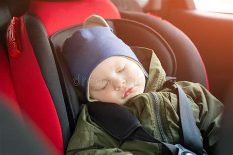 Bambino che dorme in un seggiolino auto reclinato
