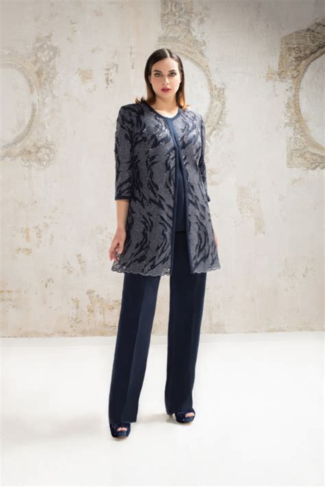 Mamma con cappottino elegante sopra pantaloni per Battesimo