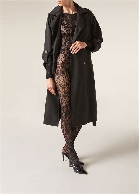 Esempio di layering look con tuta in pizzo sotto abito satin, completato da una giacca in pelliccia ecologica
