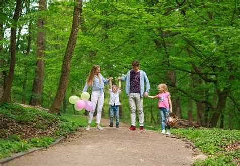 genitori con gemelli che passeggiano in un parco cittadino