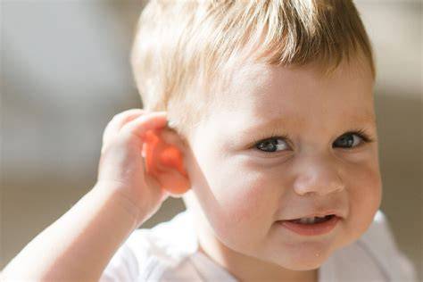 Bambino che si tocca l'orecchio con espressione sofferente