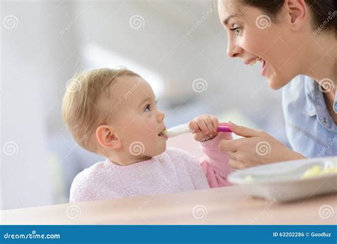 Neonata che mangia con cucchiaino