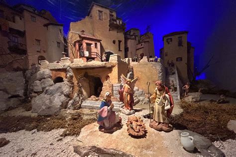 Zampognaro che suona davanti a un presepe tradizionale in un villaggio di montagna