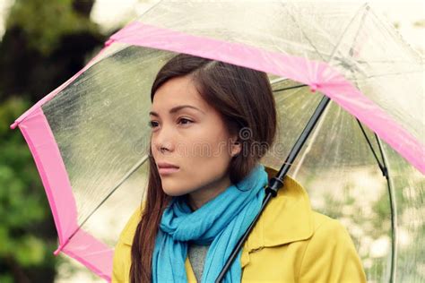 Un'adolescente con un'espressione pensierosa, sotto una pioggia leggera