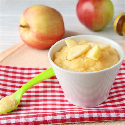 Bambino di 6 mesi che assaggia una purea di frutta