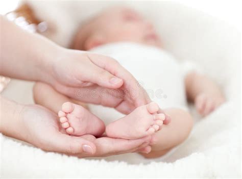 Mani di genitori che stringono i piedini di un neonato