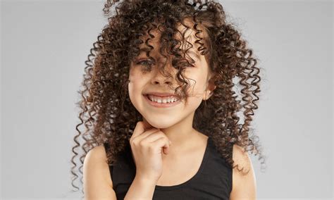 Bambina con capelli ricci naturali e voluminosi