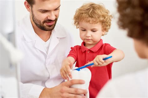 Odontoiatra pediatrico che esamina la bocca di un bambino