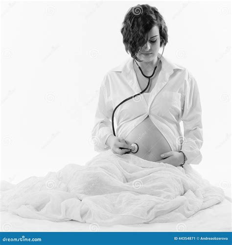 Immagine di una donna incinta che ascolta il battito del proprio cuore