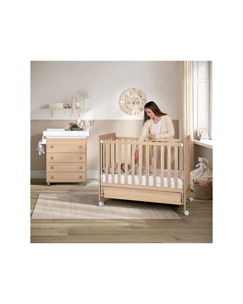Cameretta neonato accogliente con lettino in legno e fasciatoio in stile coordinato
