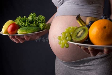 Donna incinta che sceglie frutta e verdura