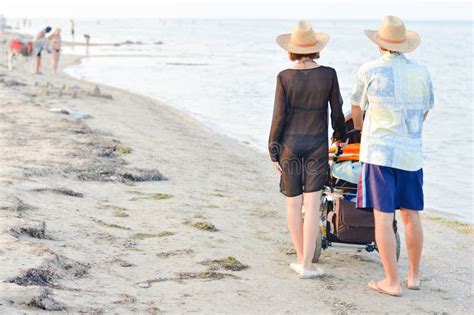 Famiglia felice a Cesenatico con passeggino a noleggio sulla spiaggia