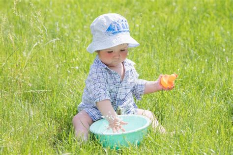 Bambino che gioca con l'acqua in una vaschetta