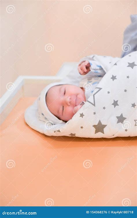 neonato avvolto in una coperta di cotone in una culla