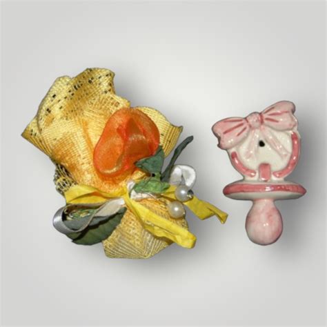 rappresentazione artistica di un ciuccio stilizzato in argento o ceramica, simbolo classico del battesimo