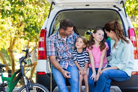 famiglia felice che prepara i bagagli per un viaggio in auto