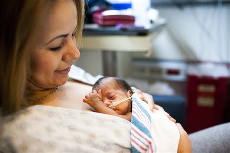 Mother holding a premature baby in kangaroo care