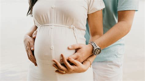Una coppia felice che frequenta un corso pre-parto partecipativo con un'ostetrica