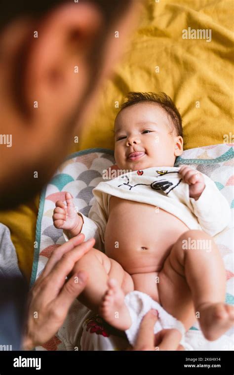 genitore che gioca con il bambino durante il cambio pannolino
