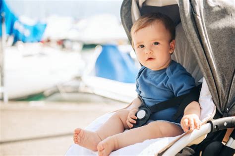 Bambino seduto su un passeggino Jane Nomad in un parco