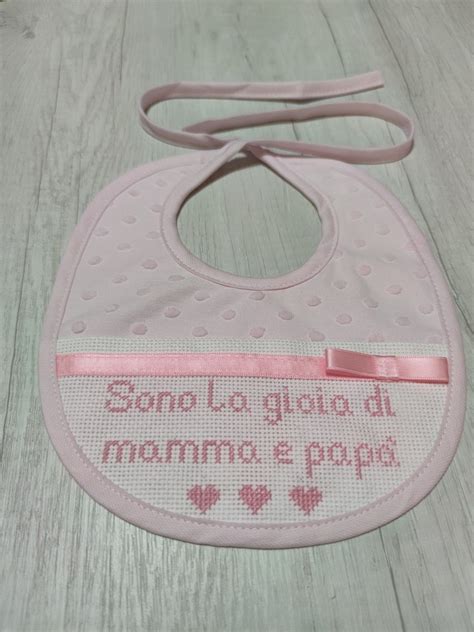Primo piano di un ricamo a punto croce su un bavaglino per neonato