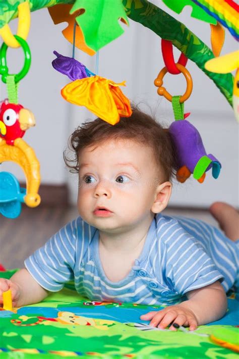 neonato che gioca su una palestrina colorata con sonagli appesi