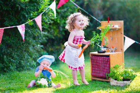bambini che giocano con una cucina giocattolo simulando la preparazione del pranzo