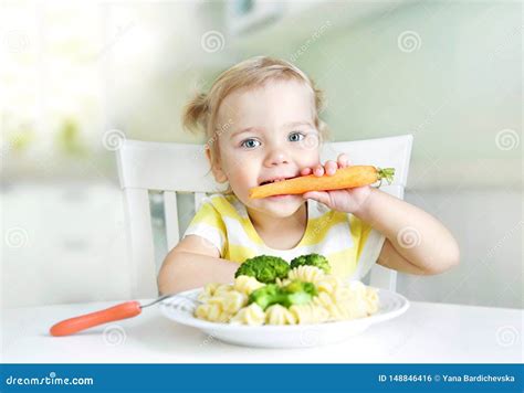 Bambino che mangia verdure colorate