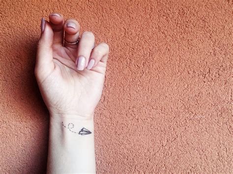 Un tatuaggio stilizzato di un ciuccio minimalista posizionato sul polso