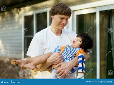 foto di un padre che tiene in braccio il proprio figlio, sottolineando il legame affettivo