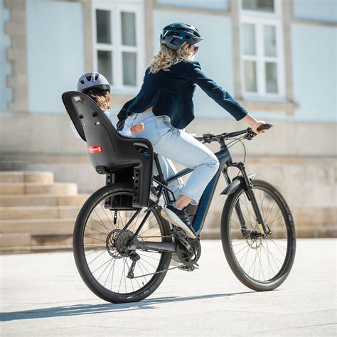 Bambino felice su un seggiolino posteriore di bicicletta