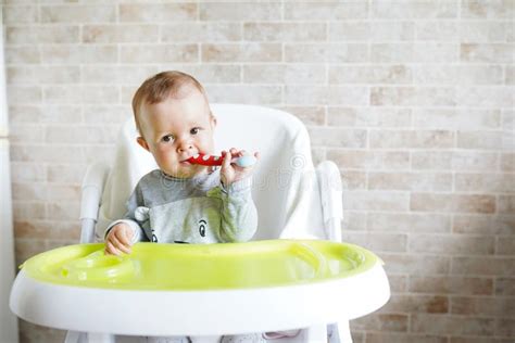 Bambino nel seggiolone con cucchiaino