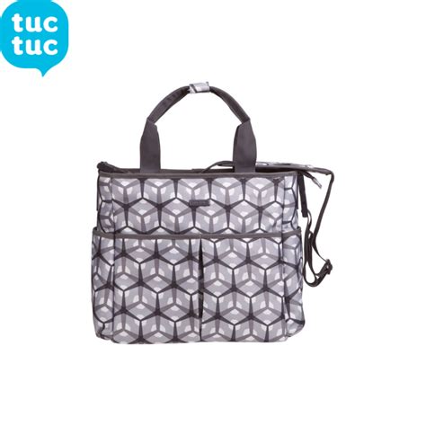 Una collezione di accessori Tuc Tuc inclusa una borsa, un bavaglino e un gioco, disposti in modo ordinato su una superficie neutra
