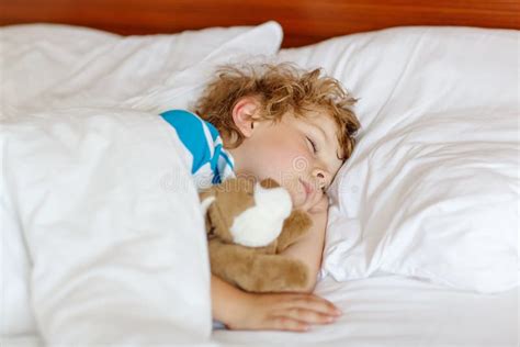 Bambino che dorme nel letto con un sorriso