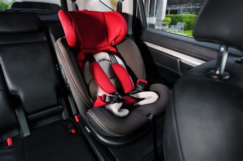 Genitore che controlla il bambino nel seggiolino tramite smartphone