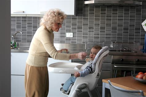 Un bambino che osserva i genitori dal seggiolone durante la pappa
