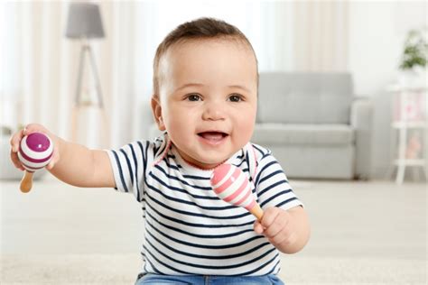 Bambino di 3 mesi che gioca con un sonaglio
