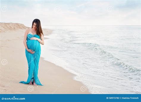modella incinta sulla spiaggia