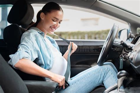 Donna incinta in auto con cintura di sicurezza