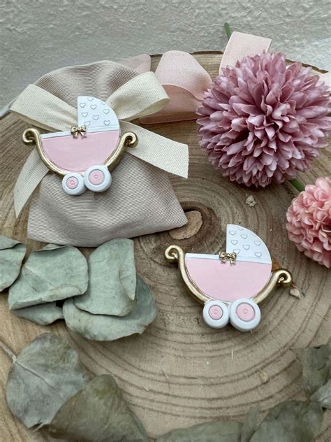 Dettaglio di una culla rosa aperta con confetti confezionati all'interno