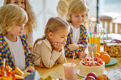 Bambini festeggiano compleanno con palloncini e torta