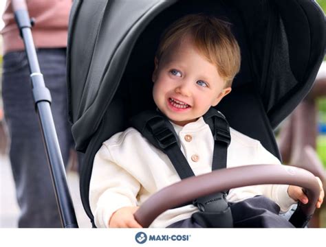 Bambino felice su un passeggino Maxi-Cosi