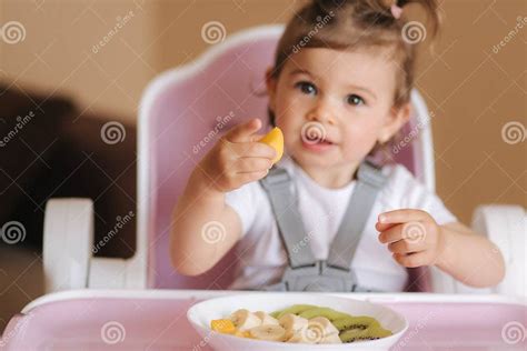 Bambino che assaggia la prima frutta con curiosità