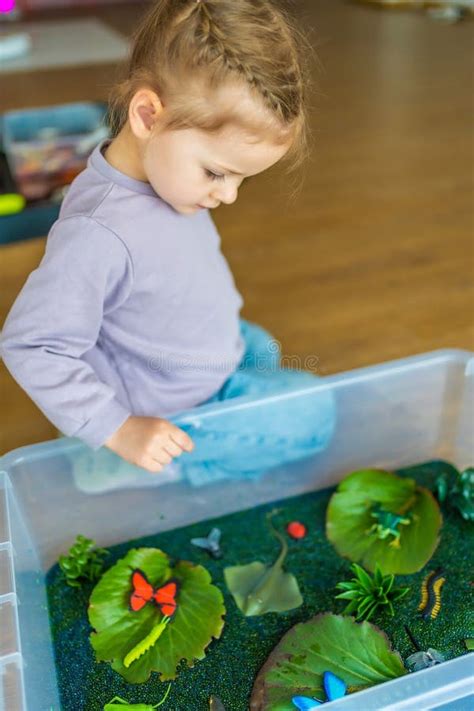 bambina che gioca con una scatola sensoriale