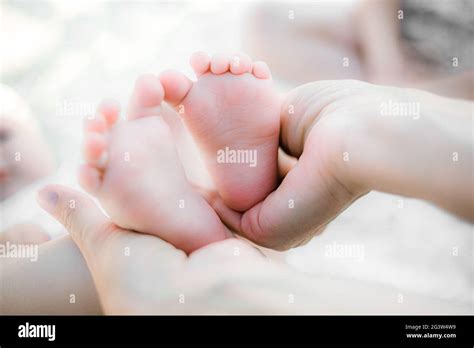 Mani di un genitore che veste delicatamente un neonato