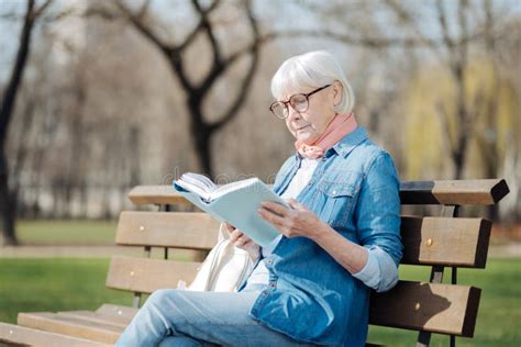Persona anziana serena che legge un libro