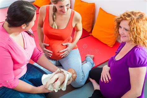 Ostetrica che spiega a un gruppo di donne incinte